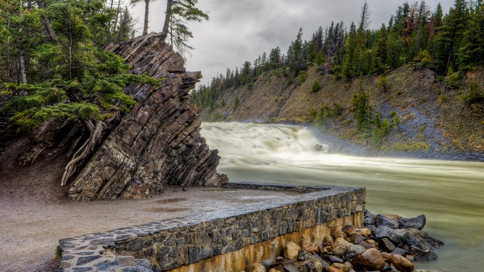 Waterfall flowing through a rocky gorge with trees