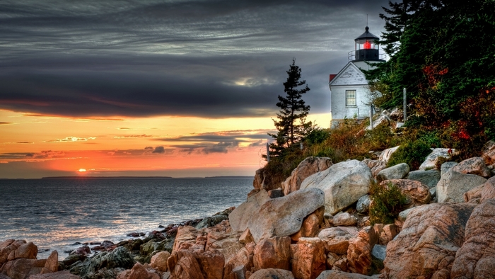 Lighthouse on a rocky coast at sunset