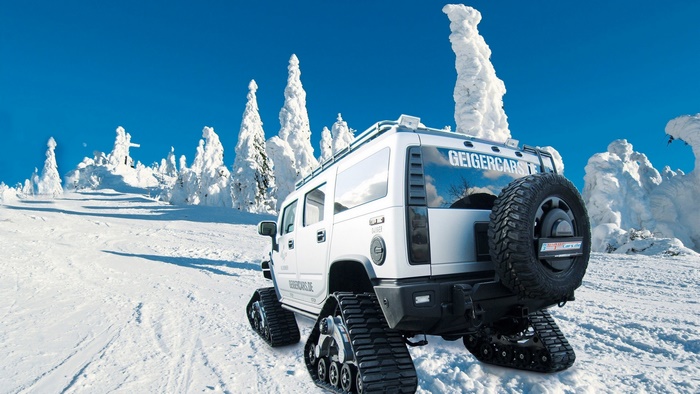 White Geiger Hummer with tracks in snowy forest