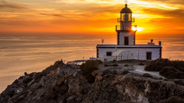 Lighthouse at Sunset Over Calm Sea