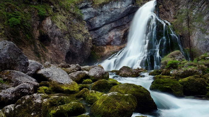 Waterfall cascading over mossy rocks in a forest