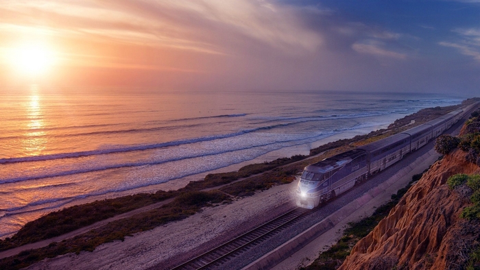 Train traveling along the coast at sunrise