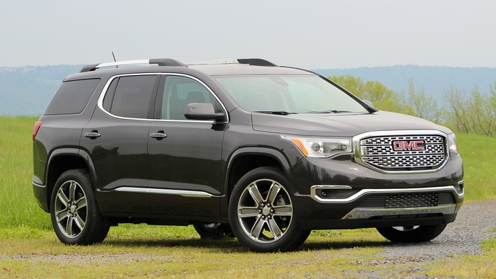 Dark gray GMC Acadia SUV parked on a dirt road
