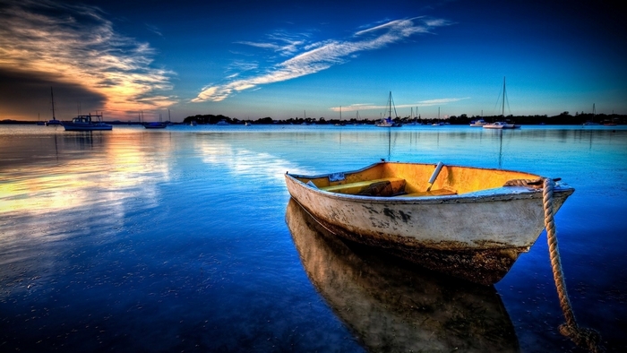 Boat on calm water with reflections and sky