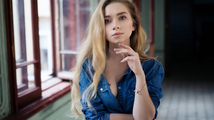Woman in denim shirt by window