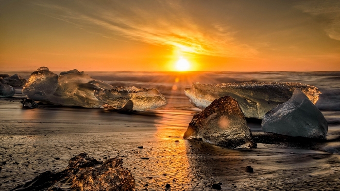 Ice chunks on a beach at sunset