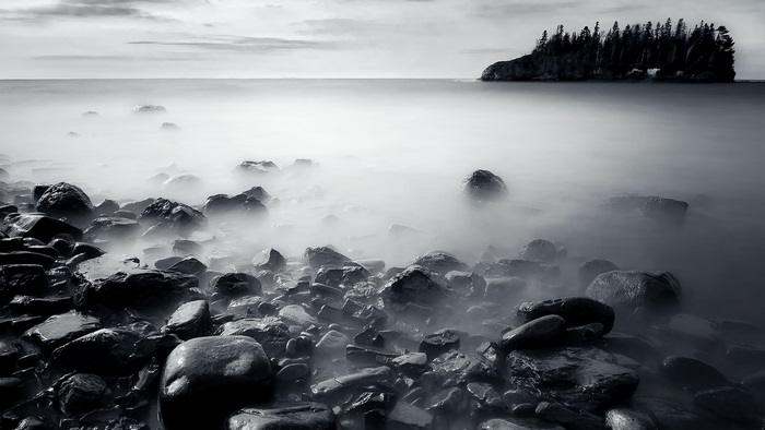 Misty Rocky Lakeshore with Island and Calm Water