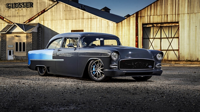 Customized 1955 Chevrolet Bel Air in front of industrial buildings