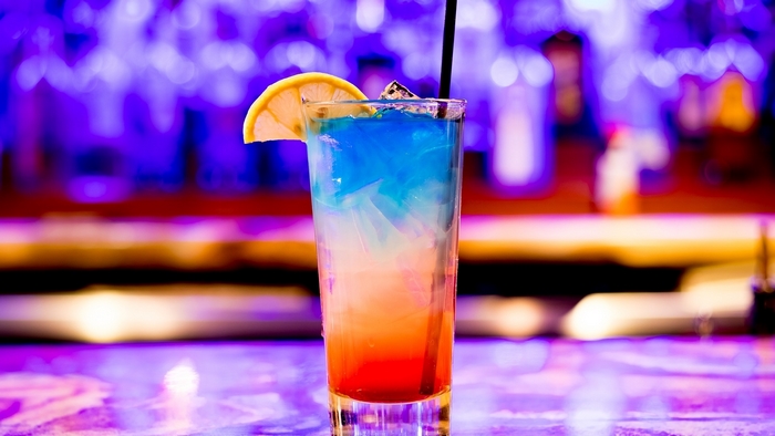 Colorful layered cocktail with lemon slice