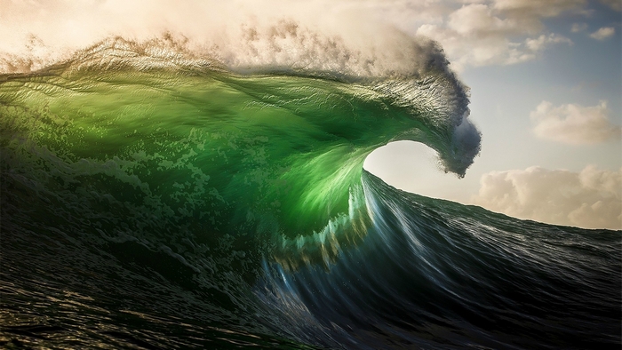 Majestic Ocean Wave Under Cloudy Sky