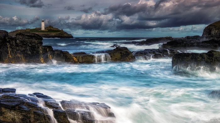 Lighthouse on a rocky island with stormy seas