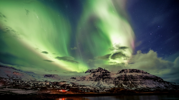 Aurora Borealis over snowy mountains in Iceland