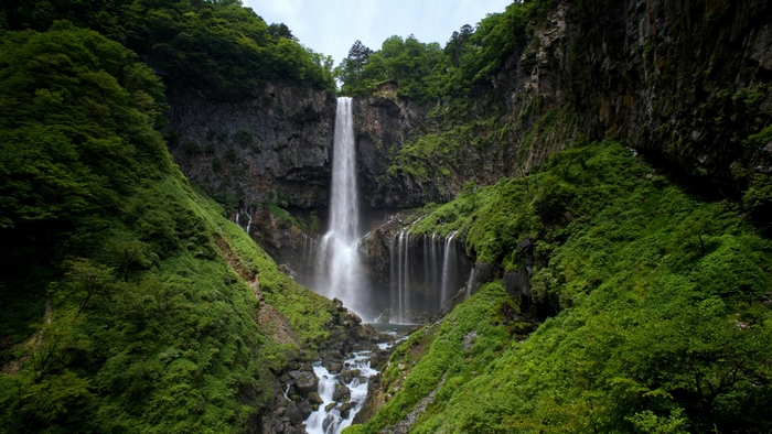 Waterfall in a lush green mountain landscape in Japan