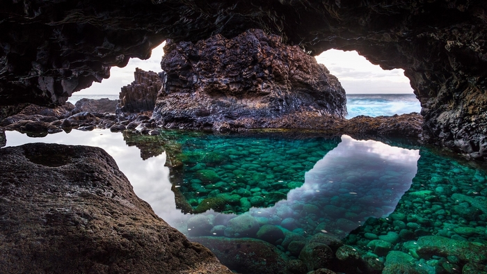Cave pool with turquoise water and ocean view