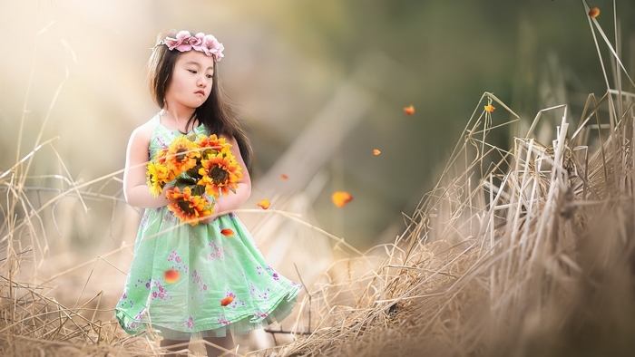 Girl with flower wreath holding sunflowers