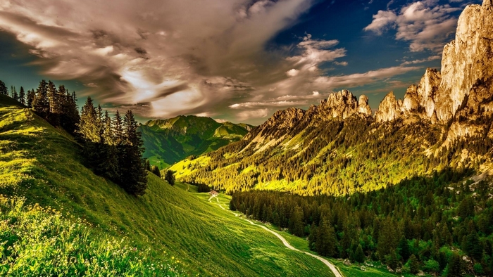 Green valley with mountains and dramatic clouds
