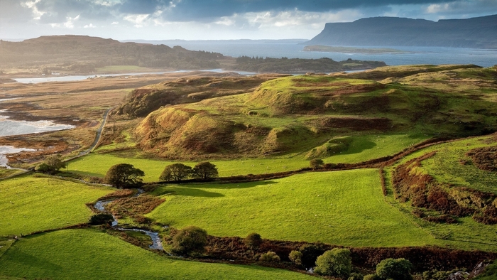 Rolling green hills and a river in the Scottish Highlands