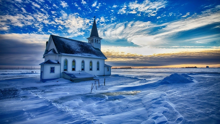 White church in a snowy landscape under a cloudy sky