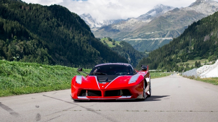 Red Ferrari FXX K driving on a mountain road