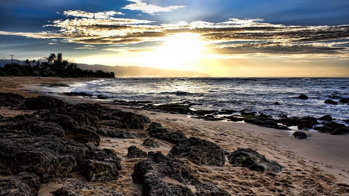 Beach with rocks and ocean at sunset