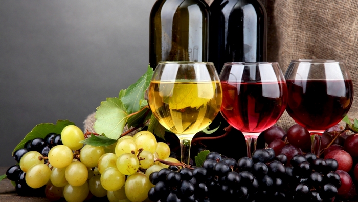 Still life with wine bottles, glasses, and grapes