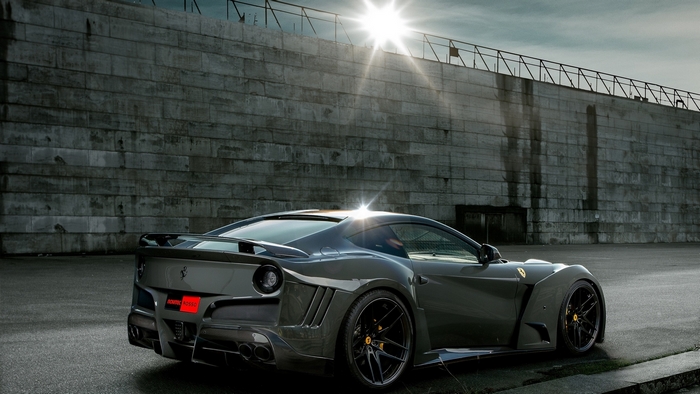 Dark Ferrari F12berlinetta parked near a concrete wall