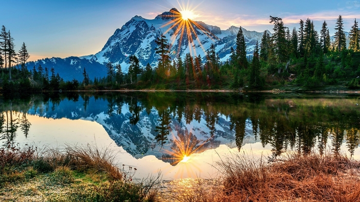 Snowy mountain reflecting in a lake at sunrise