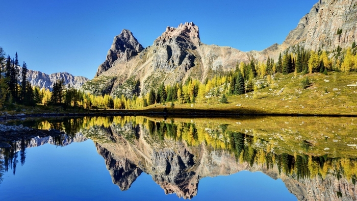 Mountain reflection in a still lake under a blue sky