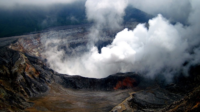 Volcano crater with smoke and clouds