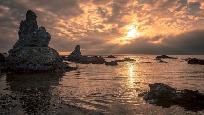 Rocky coastline at sunset with dramatic clouds