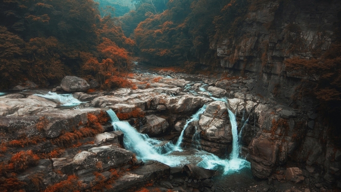 Waterfalls cascading over rocks in an autumn forest