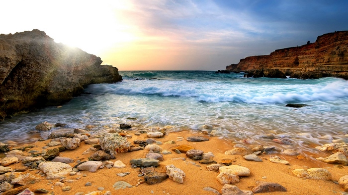 Rocky beach with waves crashing at sunset