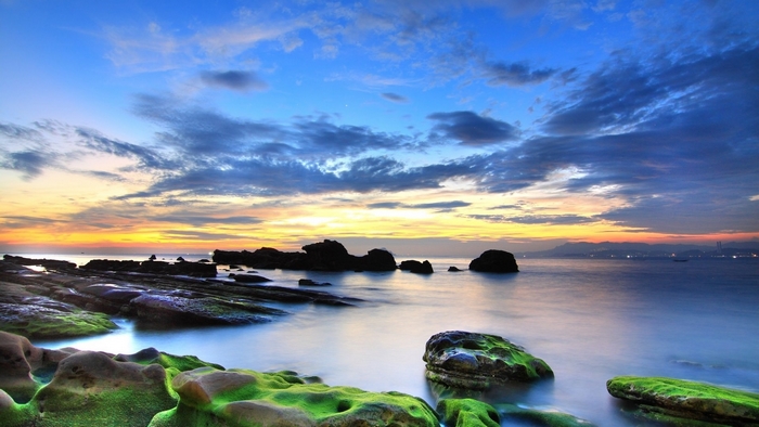 Rocky coast at sunset with ocean and clouds