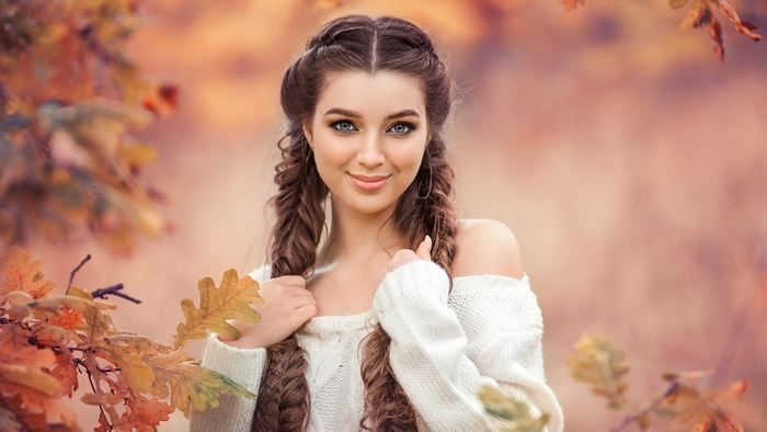 Smiling Girl with Braids in Autumn Leaves