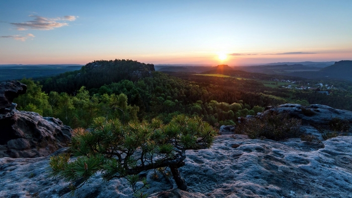 Sunset over a forested mountain landscape