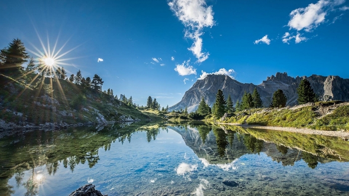 Mountain lake with sun rays and reflections