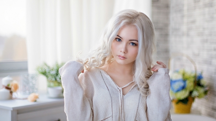 Beautiful Blonde Woman with Blue Eyes in Soft Light