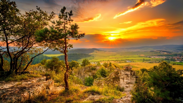 Sunset over a valley with trees and rocks