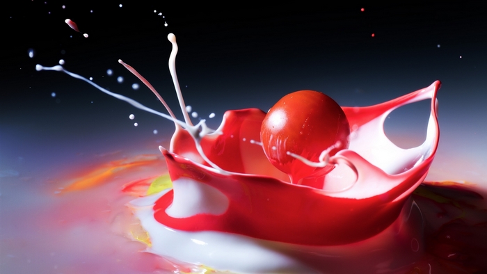 Red sphere splashing into red and white liquid
