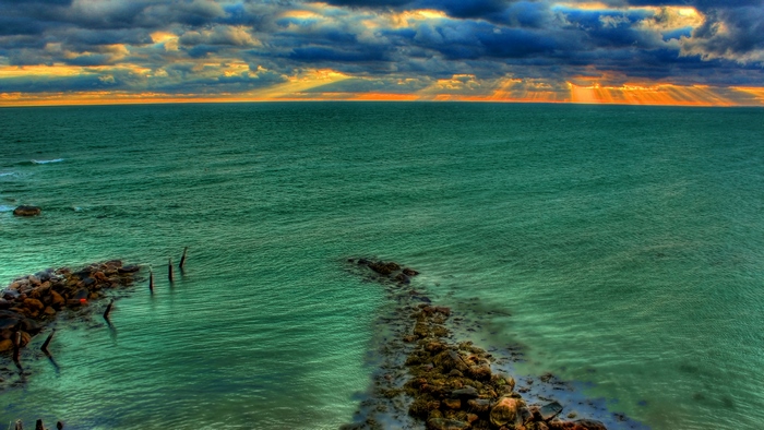 Ocean with Sunrays Breaking Through Clouds