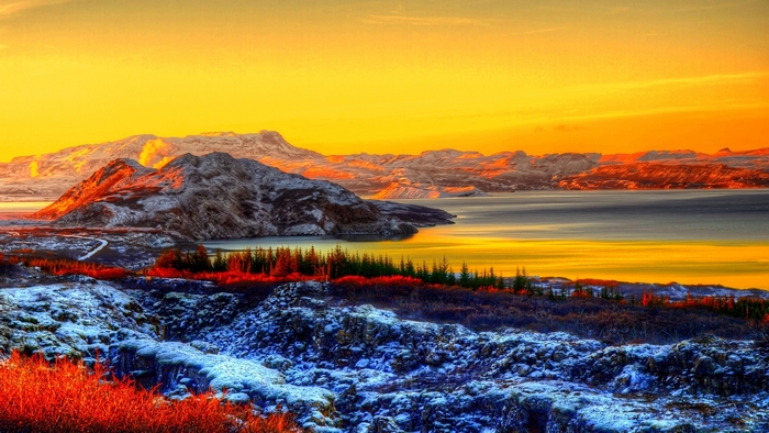 Snowy mountains and lake at sunset
