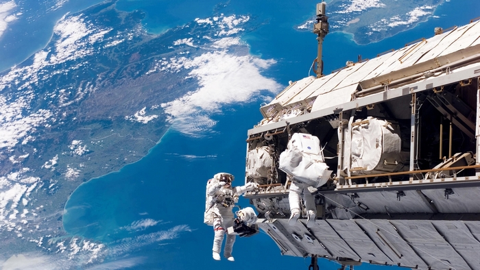 Astronauts on the International Space Station above Earth