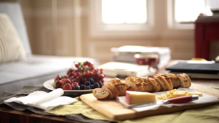 Bread, cheese, and fruit platter on a table