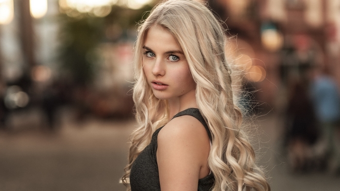 Blonde woman with blue eyes looking over shoulder