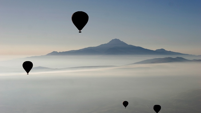 Hot air balloons over misty mountains