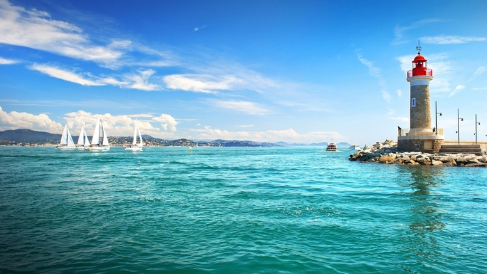Sailboats and lighthouse on a sunny day