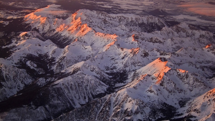 Snow-covered mountain peaks illuminated by sunlight