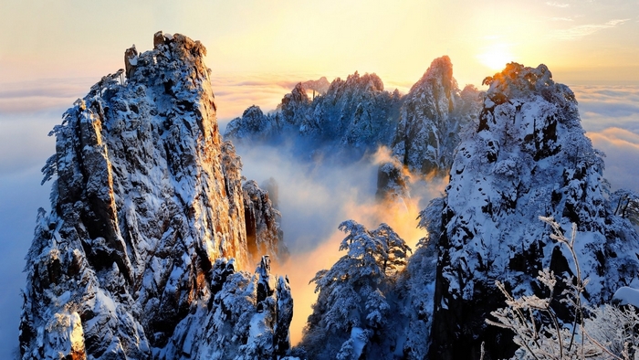 Snow-covered mountains at sunrise with clouds