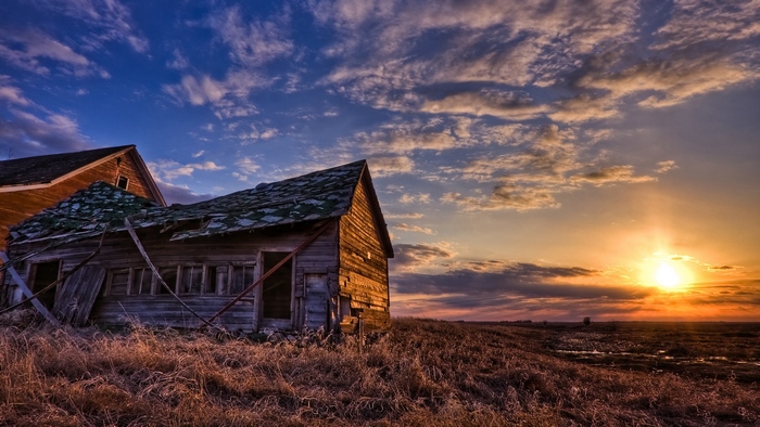 Abandoned houses at sunset with dramatic sky