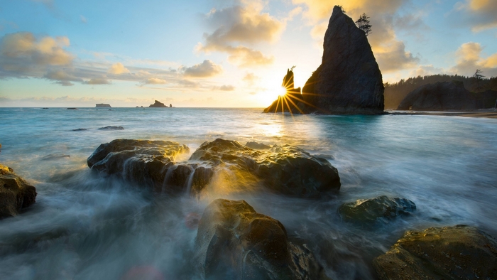 Sunset over rocky beach with ocean waves